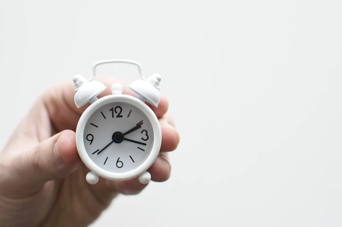Hand holding a clock, always on time