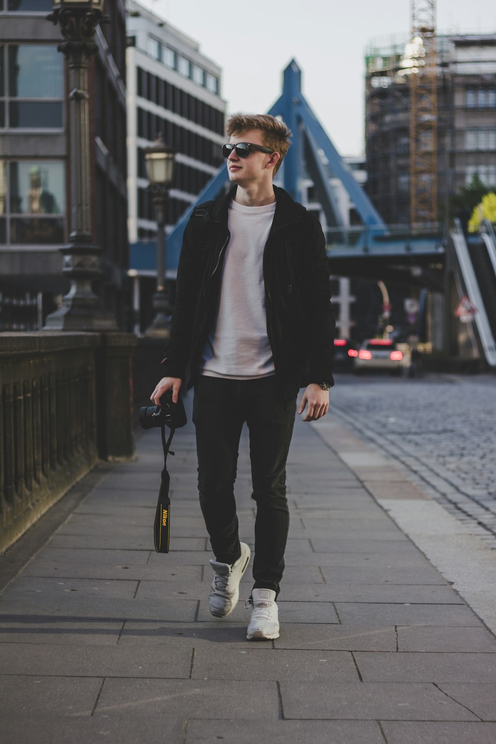 shallow focus photography of man holding DSLR camera