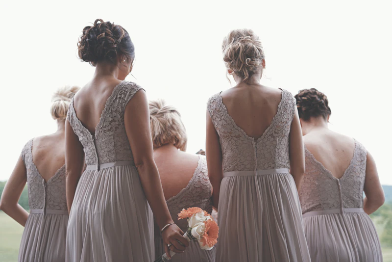Bridesmaids in soft grey gowns before the ceremony