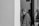 grayscale photo of woman between doors