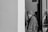 grayscale photo of woman between doors
