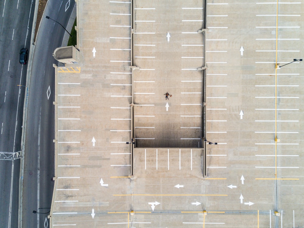 航空写真で灰色のコンクリートの駐車場に横たわる人