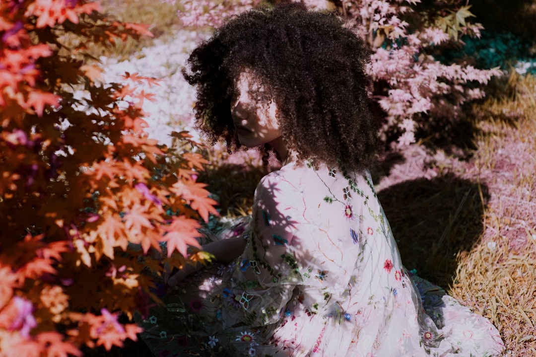 woman sitting near outdoor plants during daytime