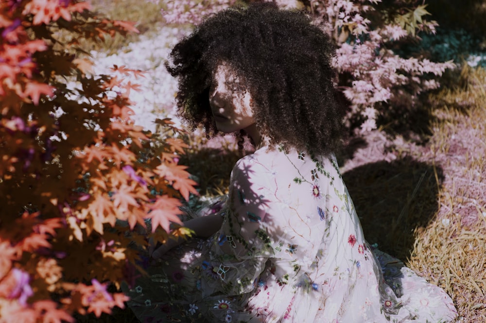 woman sitting near outdoor plants during daytime