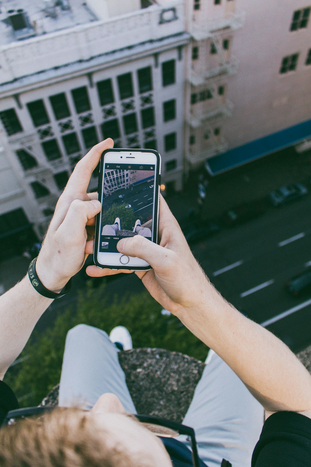 man taking photo above building