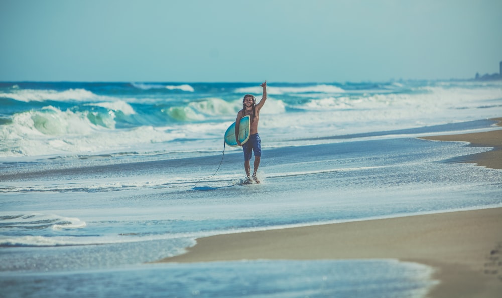 해변에서 서핑 보드를 들고 있는 남자
