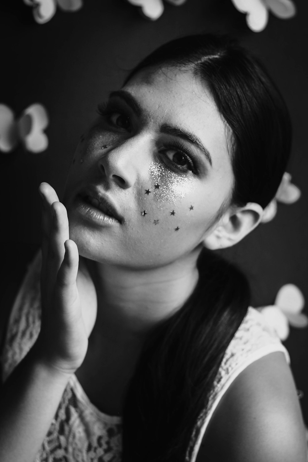 Black and white shot of attractive woman with dark hair and face glitter
