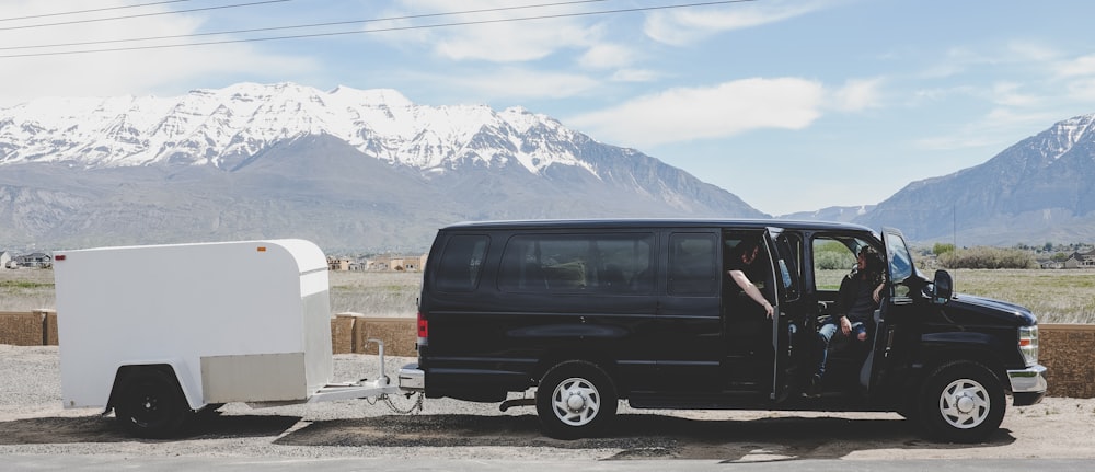 parked and opened door black van with white trailer