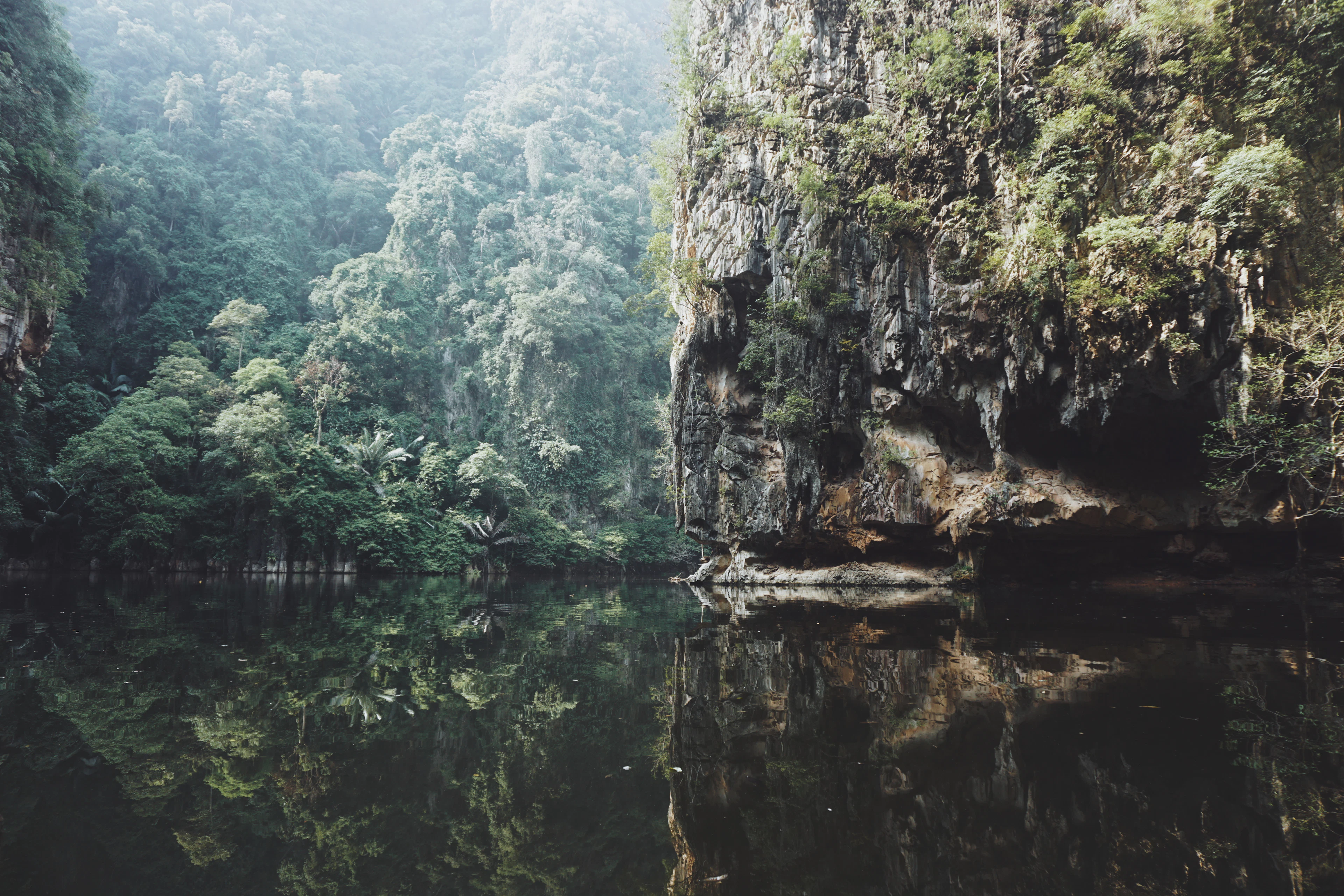 A still lake between limestone cliffs and rainforest near Ipoh