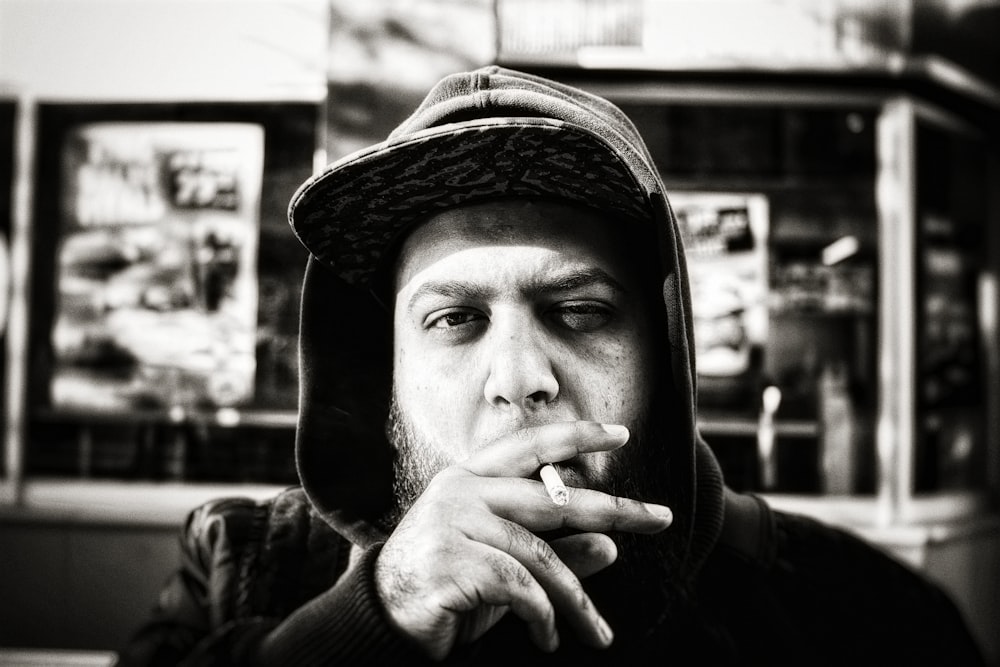 grayscale photography of man holding cigarette