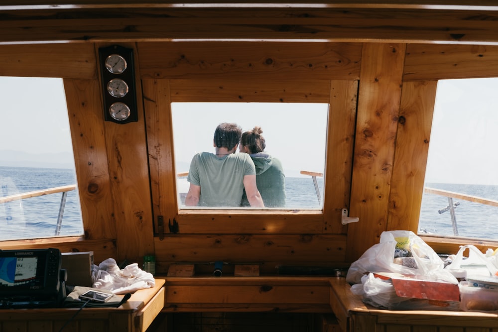 man and woman sitting in front of boat