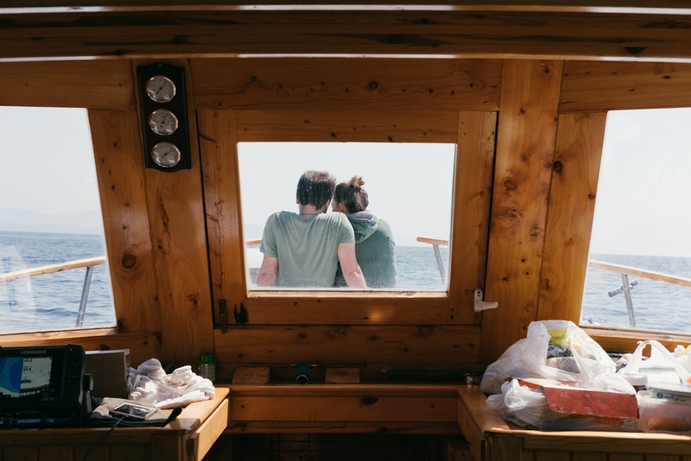 homem e mulher sentados na frente do barco