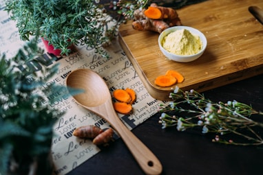 wooden ladle and chopping board with ginger during daytime
