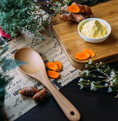 wooden ladle and chopping board with ginger during daytime