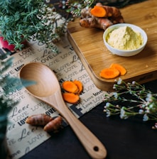 wooden ladle and chopping board with ginger during daytime