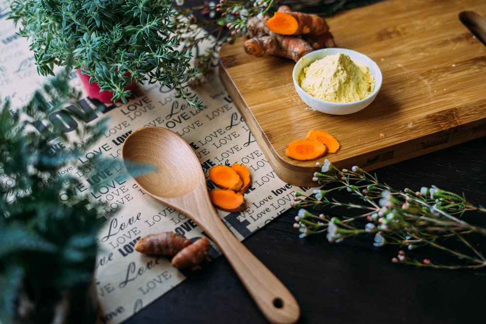 wooden ladle and chopping board with ginger during daytime