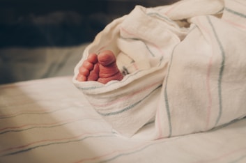 a close up of a person's hand under a blanket
