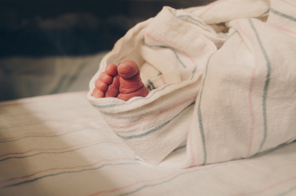 a close up of a person's hand under a blanket