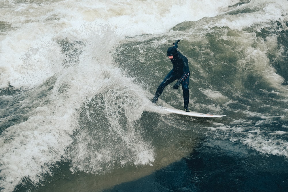 uomo sulla tavola da surf bianca mentre fa surf