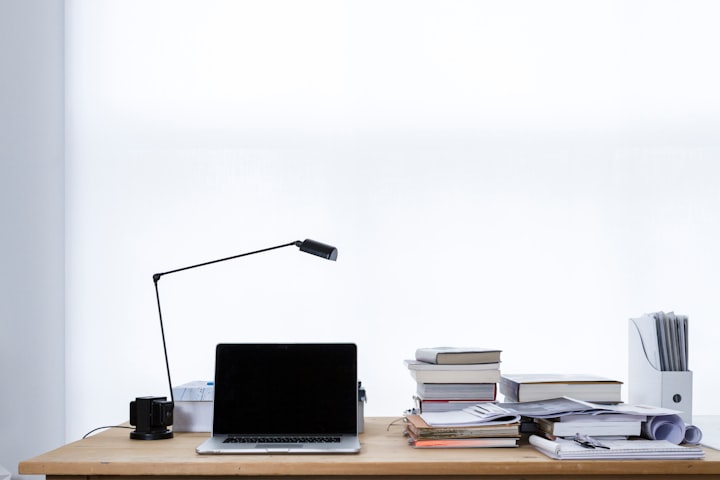 desk filled with books and clutter 