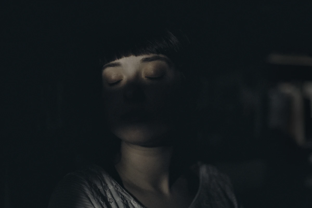 A woman embracing herself softly, self-love as practice