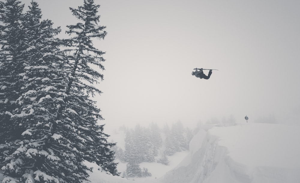 man jump on snow mountain using ski blades