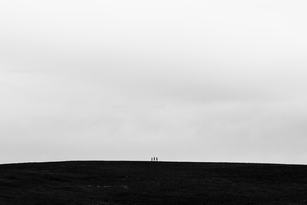 duas pessoas em pé no topo de uma colina