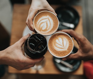 three person holding beverage cups