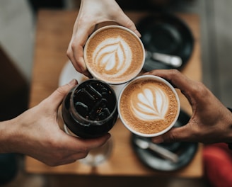 three person holding beverage cups