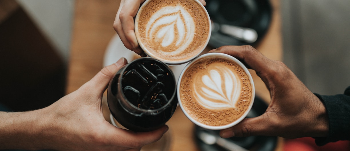 three person holding beverage cups