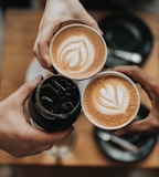 three person holding beverage cups