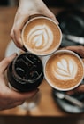 three person holding beverage cups