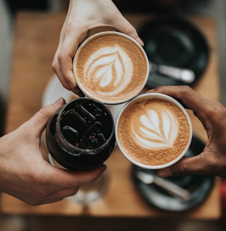 three person holding beverage cups