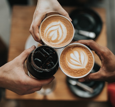 three person holding beverage cups