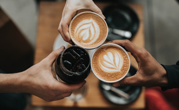 three person holding beverage cups