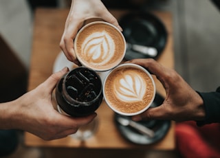 three person holding beverage cups