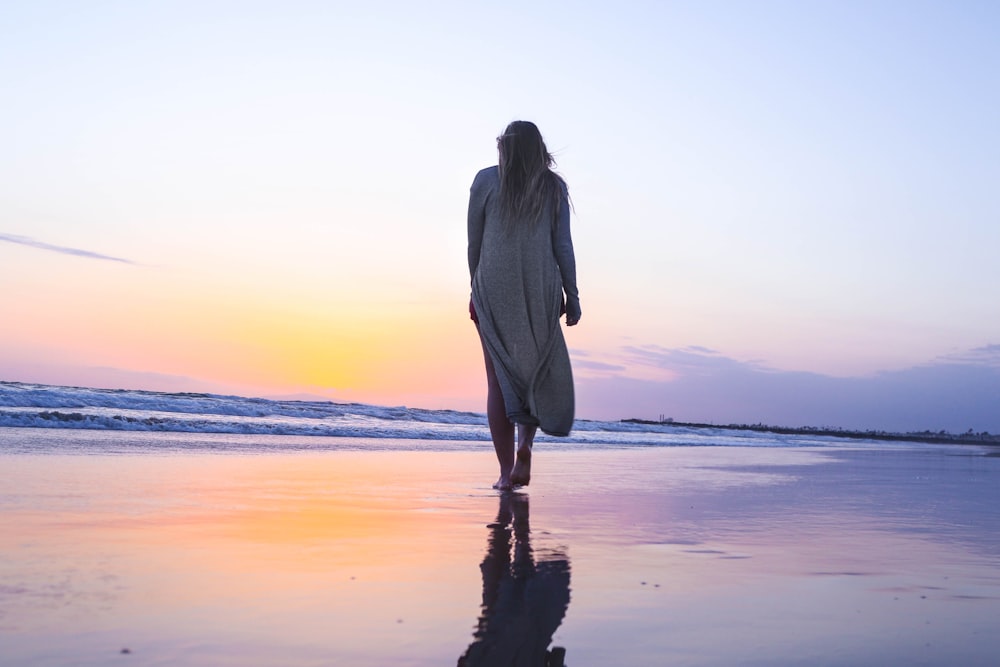 Frau steht am Strand