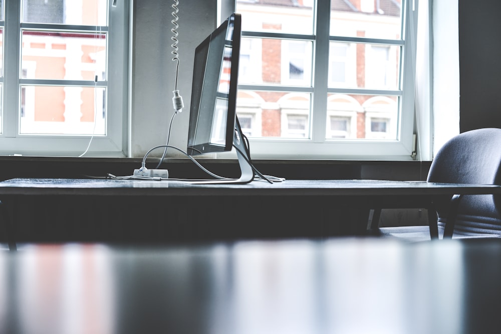 tilt shift lens photography of silver iMac on table