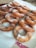 Several sugar-coated, fried doughnuts are arranged on a paper towel, displaying a golden-brown color and a light dusting of powdered sugar.
