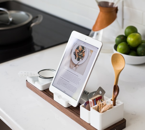 closeup photo of turned on iPad with rack on table