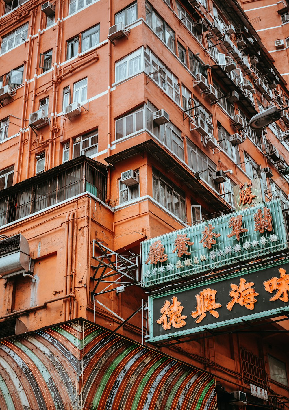 orange text with black background signage beside building structure