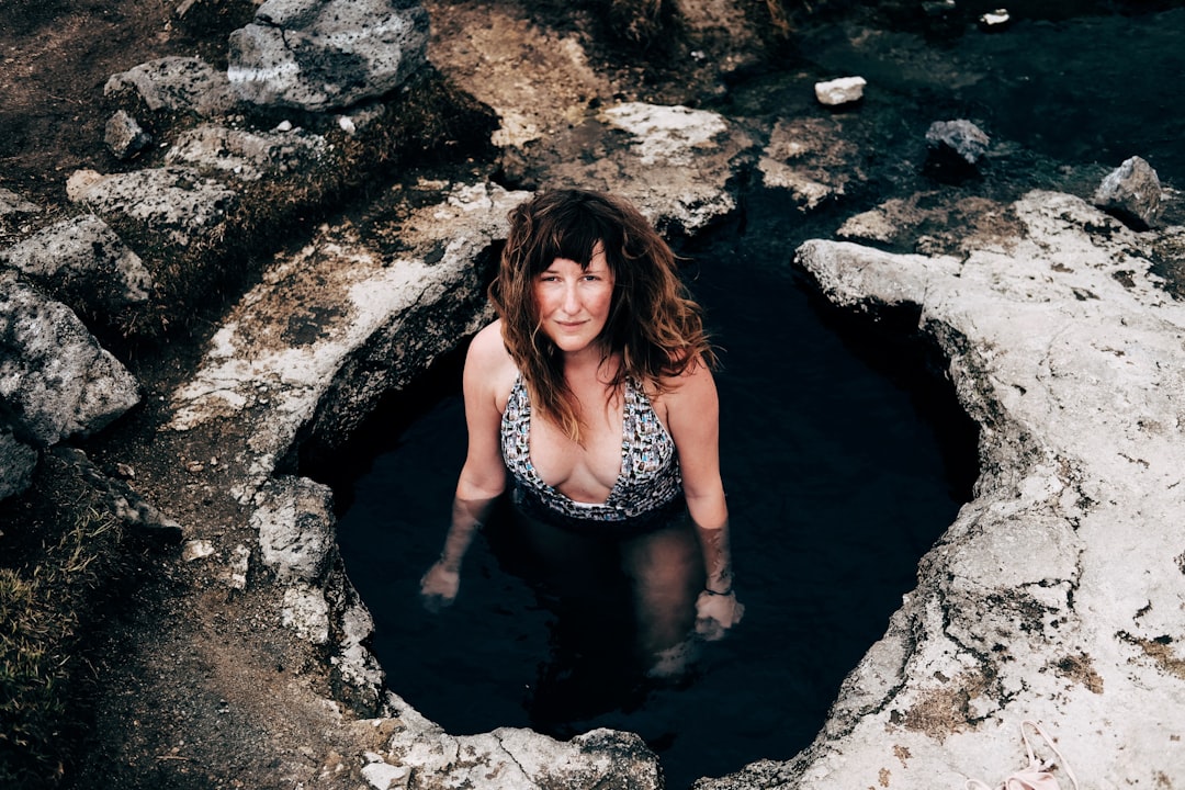 woman in cave wearing one-piece swimsuit looking upward, Hot Spring Bath