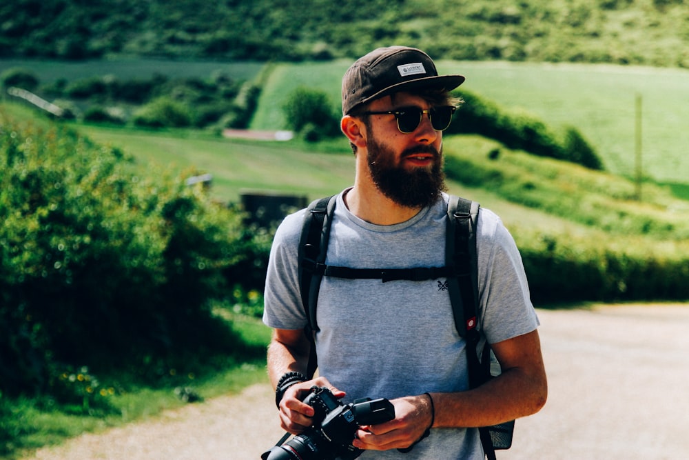 man wearing gray crew-neck t-shirt near grass field