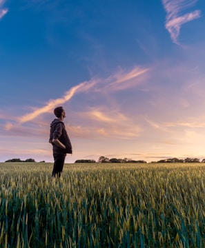 man on grass field looking at sky