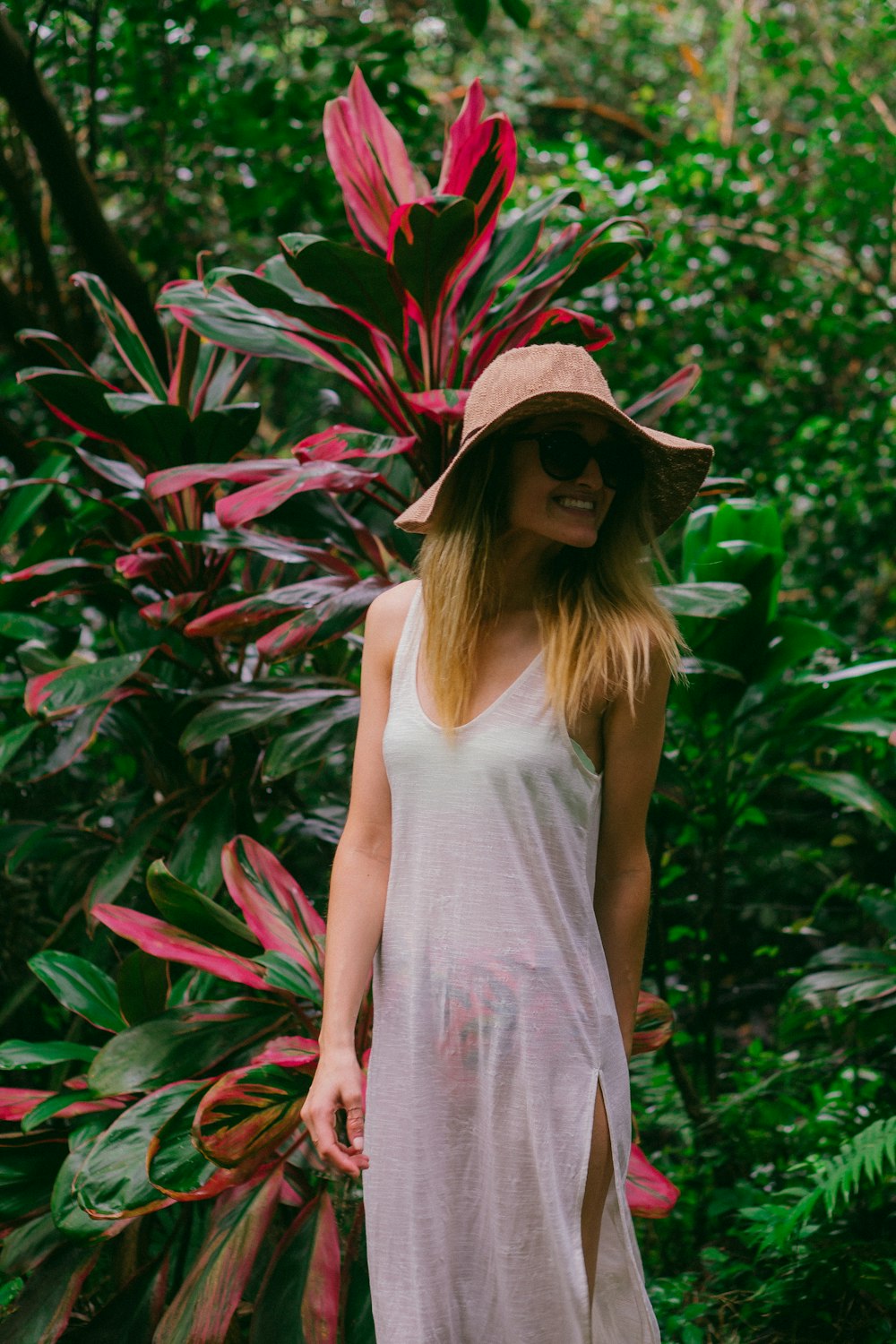 smiling woman in front of plant during daytime