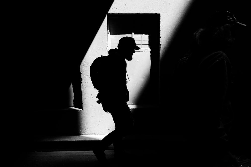 person carrying backpack walking on street