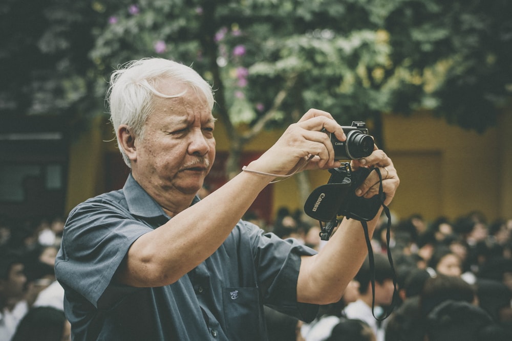 uomo che tiene la macchina fotografica