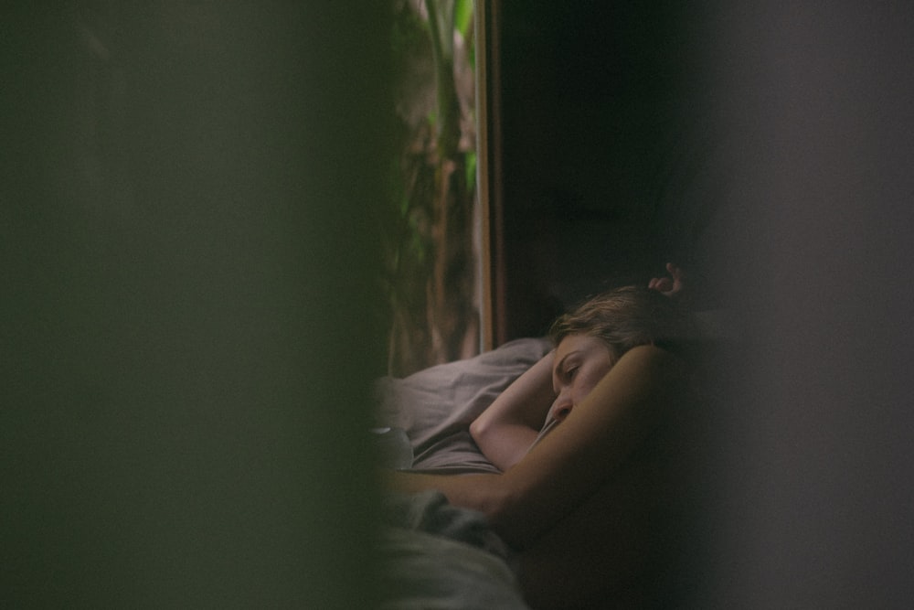 woman lying down on gray bed