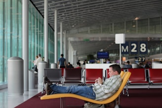 Homme assis dans un siège à l'aéroport