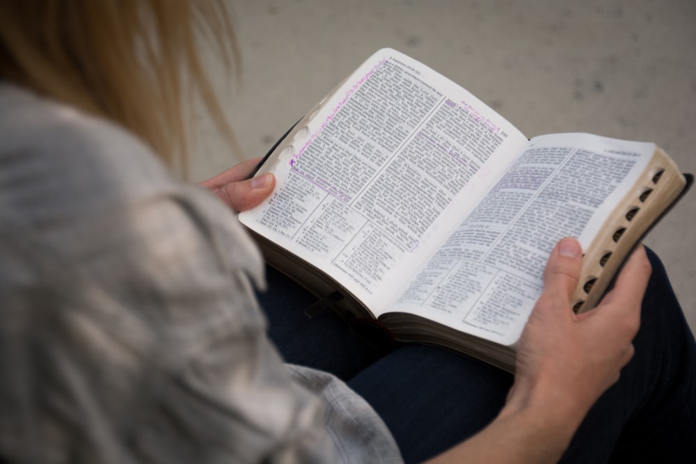 A blonde woman reading.